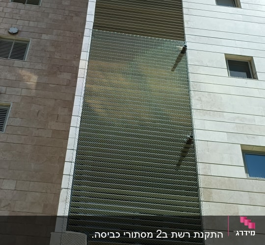 רשת מתכת מותקנת על חזית בניין למניעת יונים